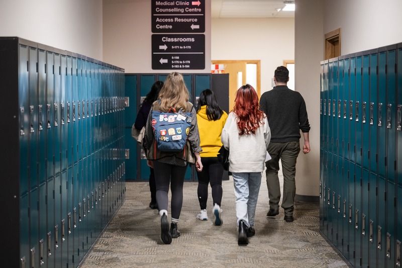 UNBC staff and students walking down a hallway