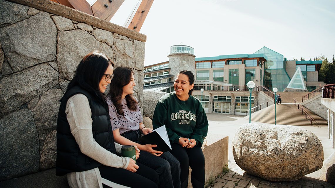 Students sitting outdoors at UNBC Prince George campus