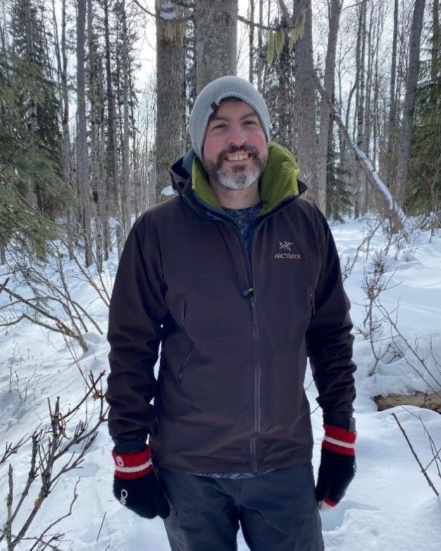 Dr. Ian Best standing in a snowy forest