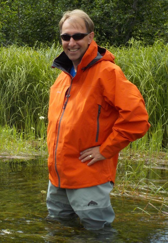 Dr. Mark Shrimpton standing in a river in hip waders