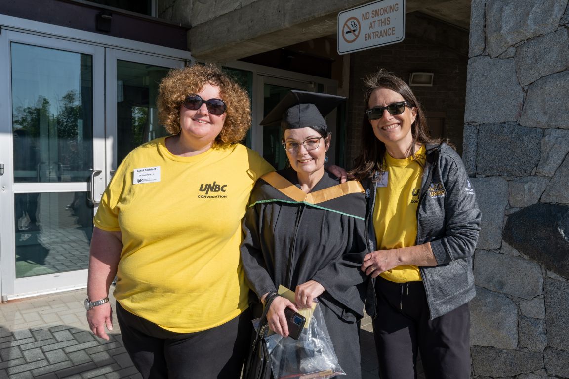 Grad in Courtyard with Event Assistants