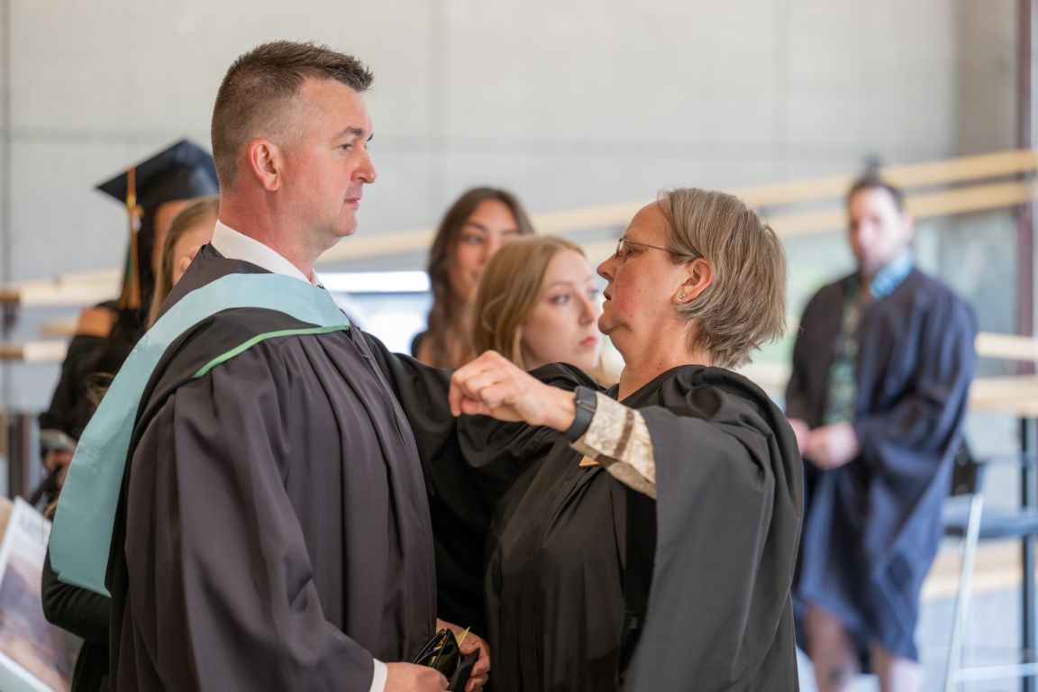 Male Grad at hooding station