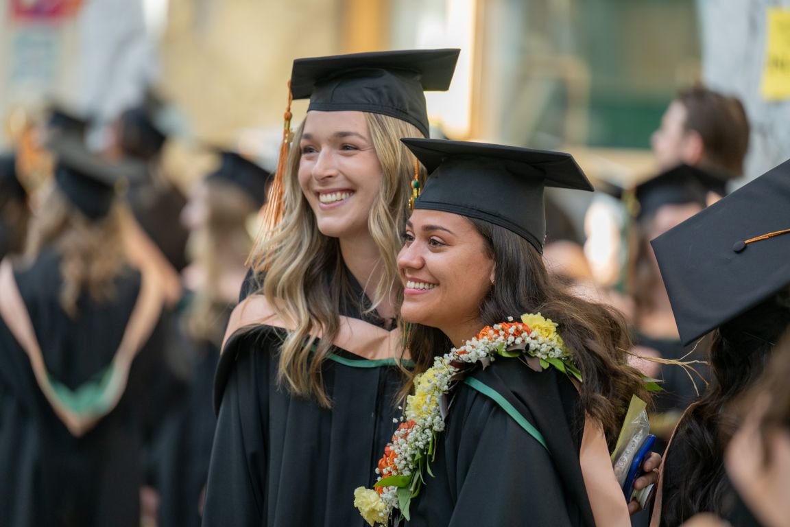 2 female grads celebrating