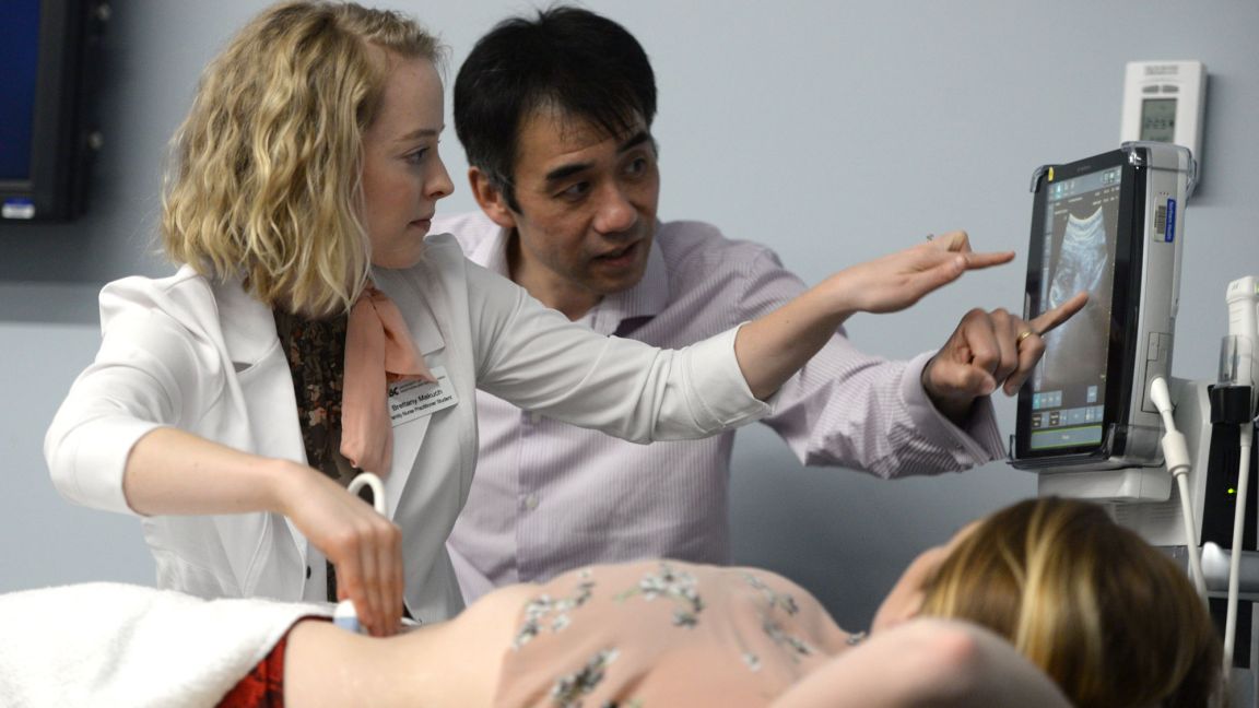 Teacher showing a student a medical instrument