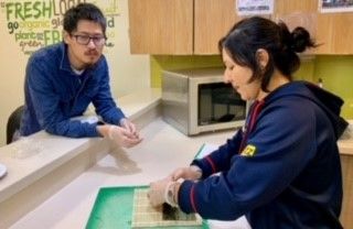 A student laying down the rice for their maki sushi