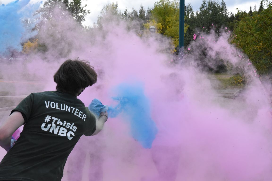 Volunteer throwing coloured cornstarch