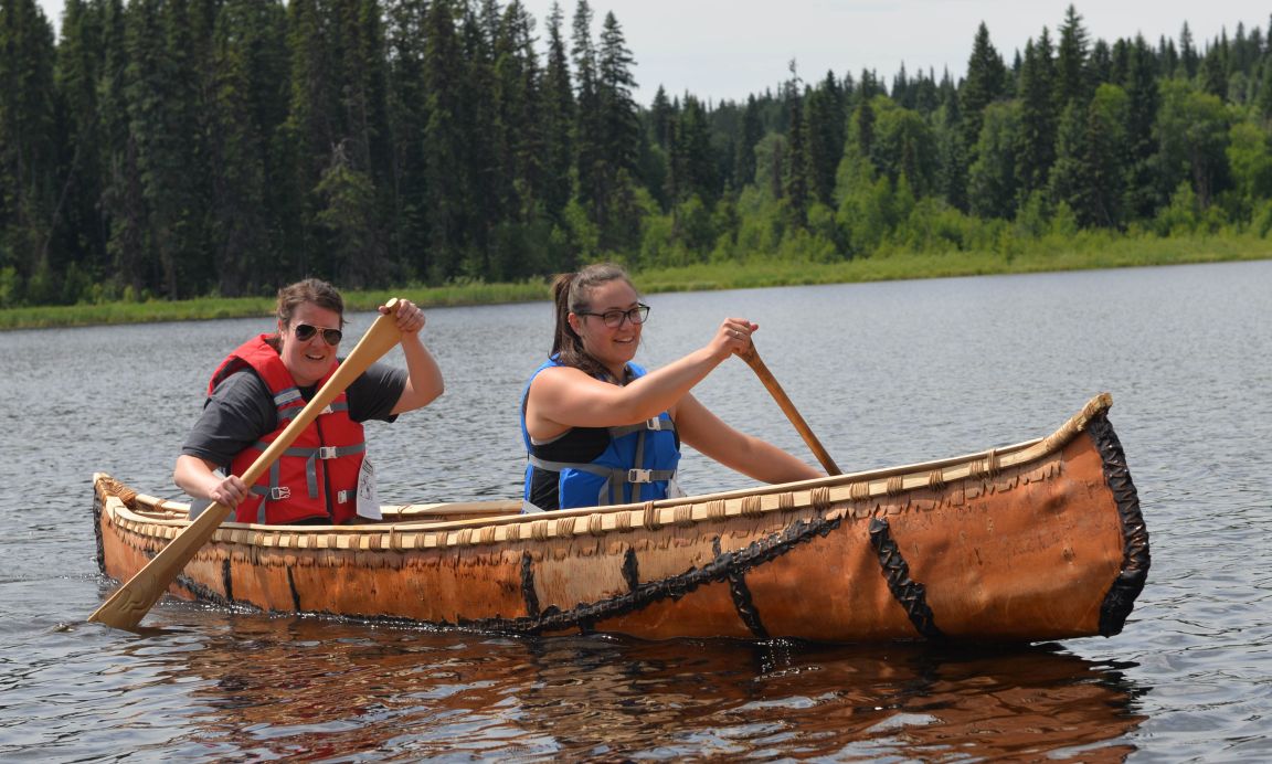 Students paddle handmade canoe