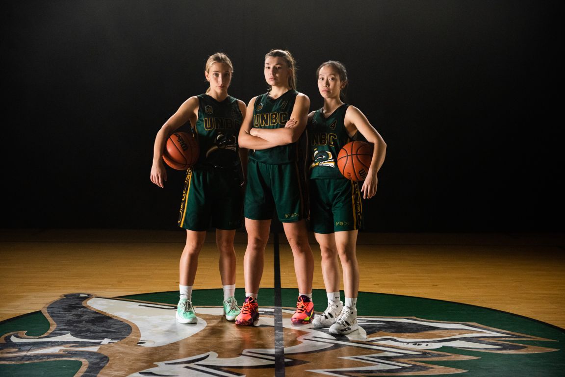 Members of the UNBC women's basketball team at centre court wear the alternate jerseys.