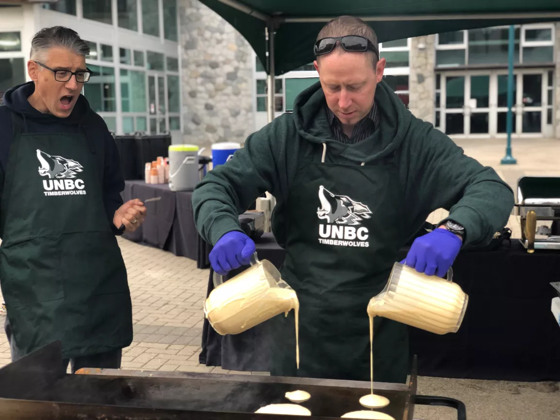 male pouring pacake mix on griddle