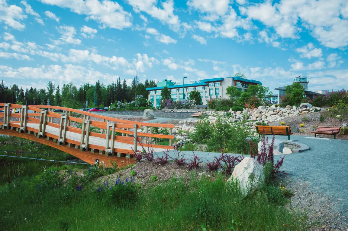 UNBC campus with bridge, looking up at building with blue sky