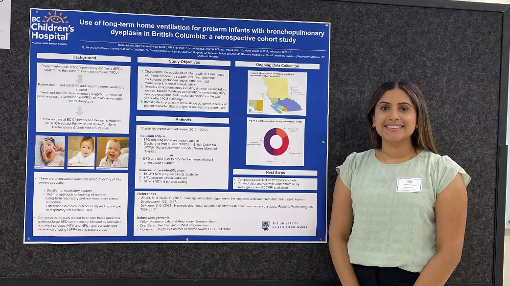 Kudrat Mundi stands beside her research poster.