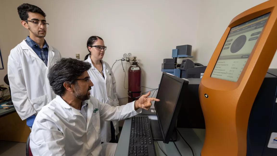 Hossein Kazemian demonstrates equipment in the Northern Analytical Lab Services facility.