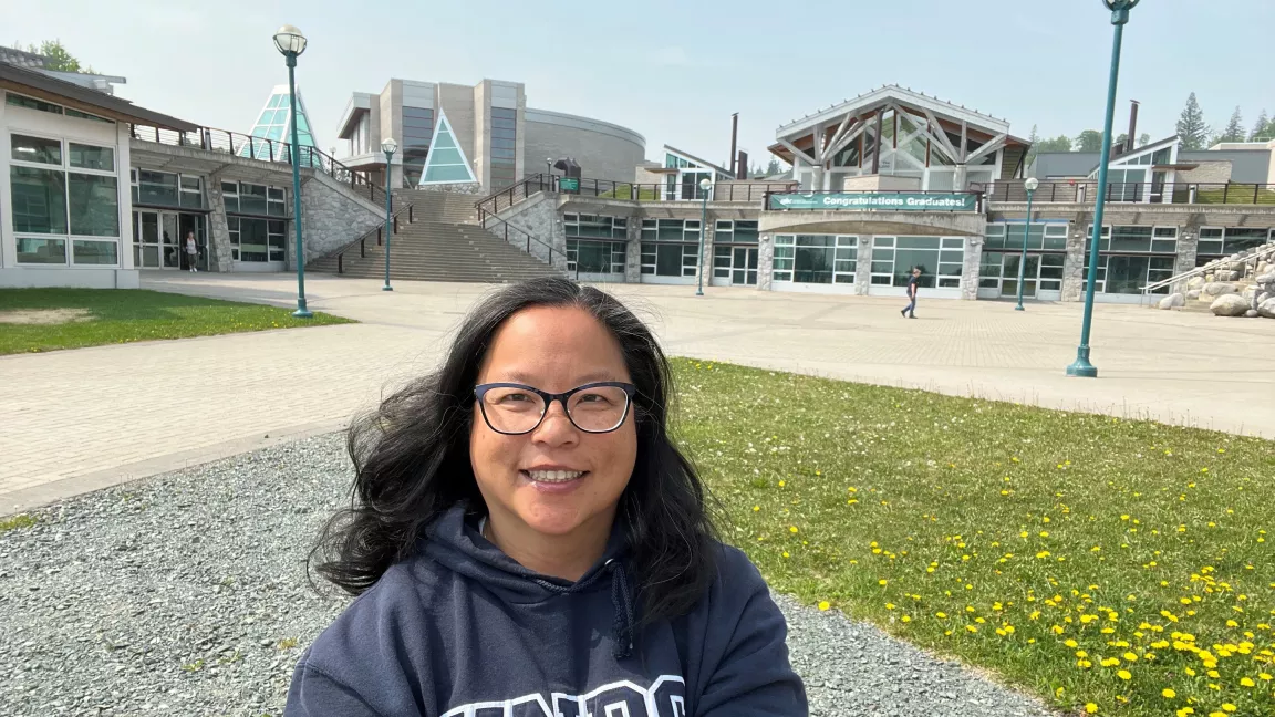 Person outside with buildings in background