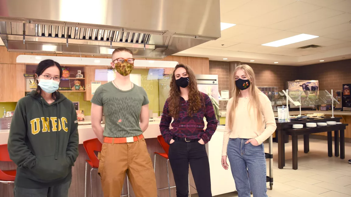 Ann Duong, Helga Holler-Busch, Shauna Kelly, Hannah Lawrence, stand in the Agora Dining Hall