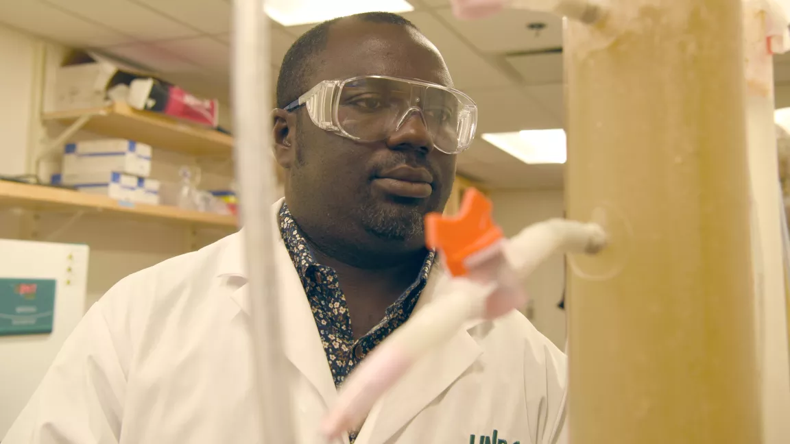 Environmental Engineering Assistant Professor Dr. Oliver Iorhemen looking at a wastewater experiment in a lab