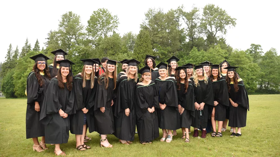 Group of students wearing black academic regalia pose for phtos