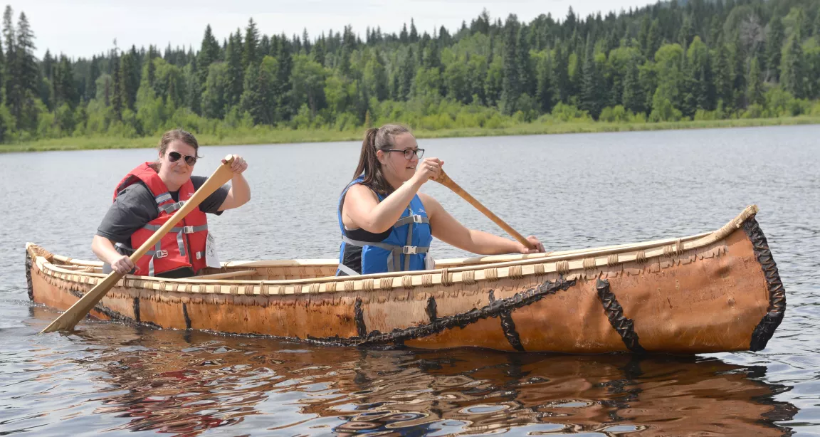 Students Nicole Hoffman and Jacey Wolfe paddle a birch bark canoe