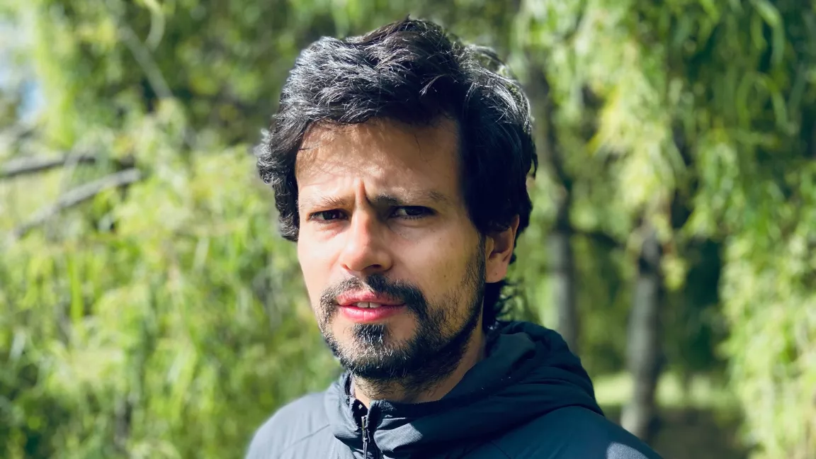 Juan Pablo Ramírez-Delgado standing outside with trees behind him