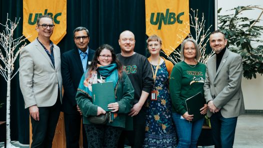 Members of the Library Services Team stand together with President Geoff Payne after receiving the Service Excellence Award at UNBC’s President’s Staff Awards event.