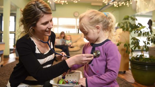 Nurse practitioner student Kristine Rowswell interacts with a child at daycare