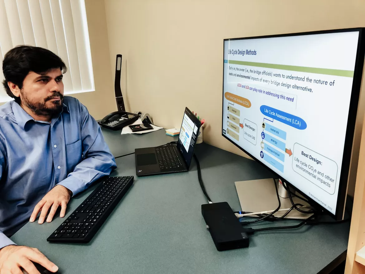 A person seated in an office, looking at a computer 