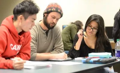 A group of students study at a classroom table.