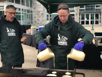 Man pouring pancake mix on griddle