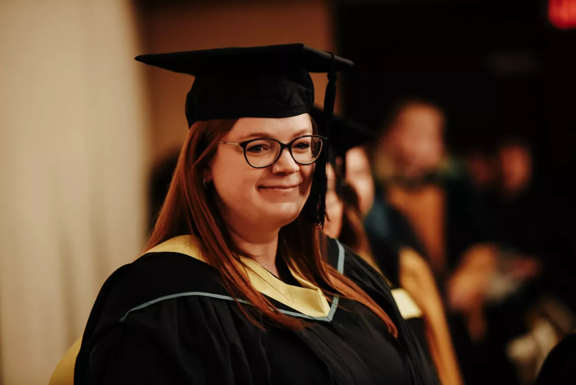 Person in academic cap and gown walks in procession