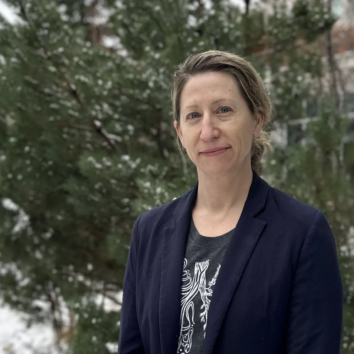 Portrait photo of someone outside in front of a tree in winter. 