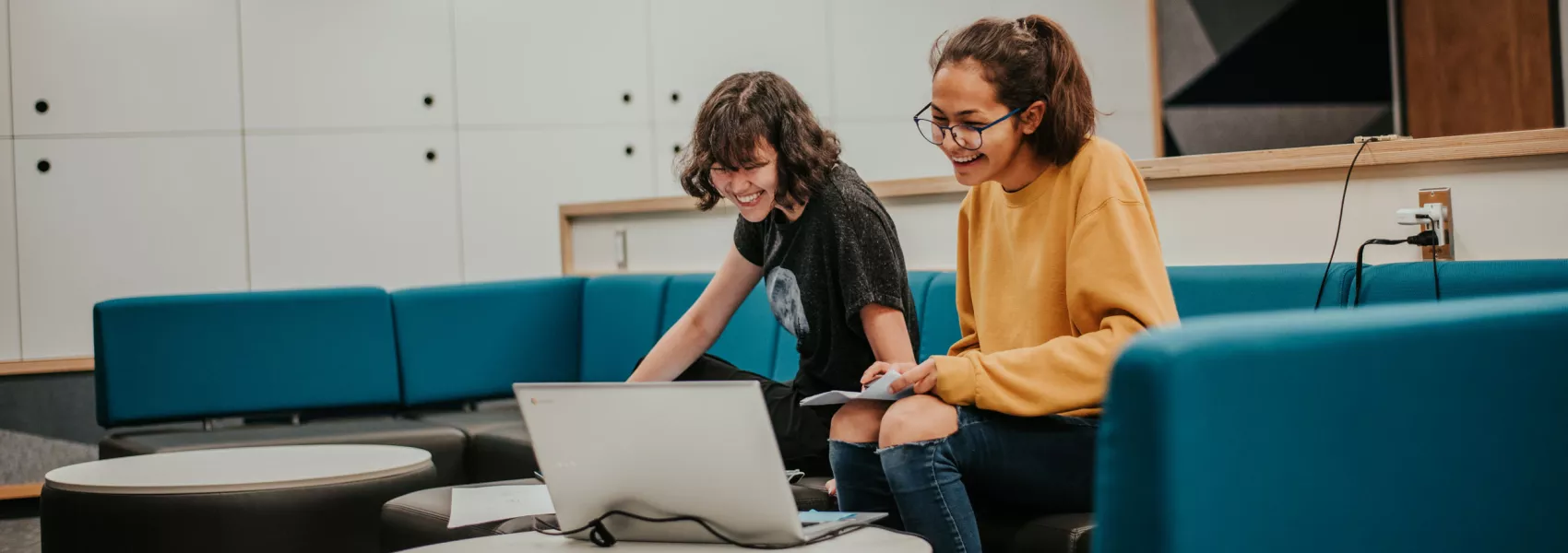 Two UNBC female students laughing while studying