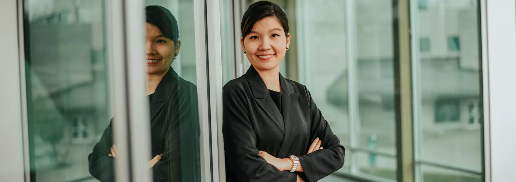 Business student leaning against glass window